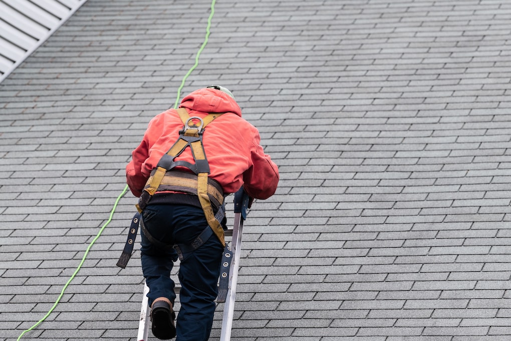 man inspecting roof before repair or replacement