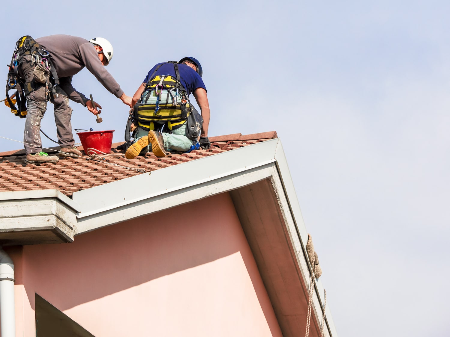 roof repair tips two workers repairing ceramic tile roof